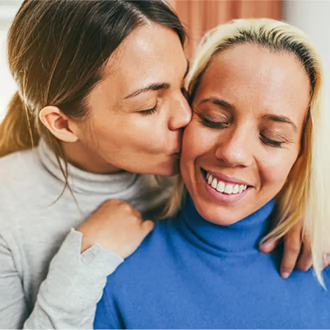 A gay couple embracing one another.